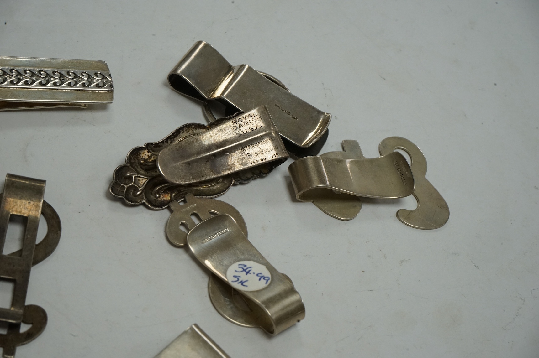Eight assorted mainly modern novelty money clips including silver pound and dollar sign, sterling dollar sign, sterling Chinese character of good fortune, Royal Danish U.S.A. International Sterling foliate design, crosse